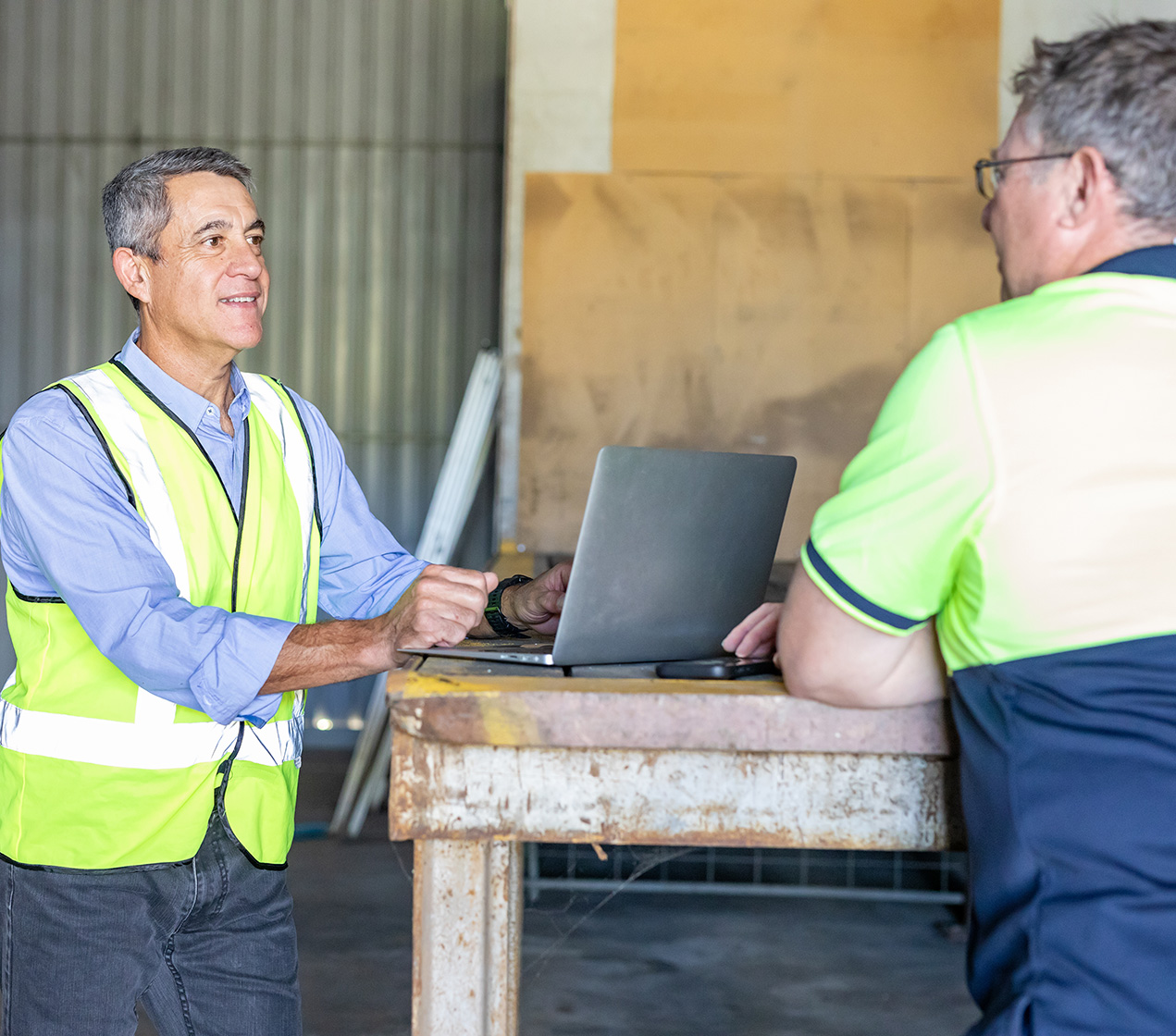 Two middle-aged men talking to each other. 